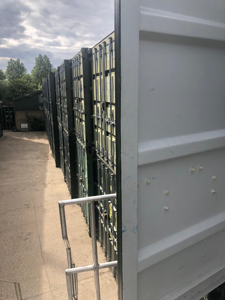 An open container door beside a row of stacked units at Elstree Storage