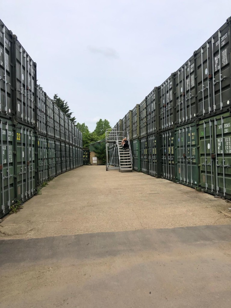A drive-up aisle at Elstree Storage, with stacked containers and access stairs